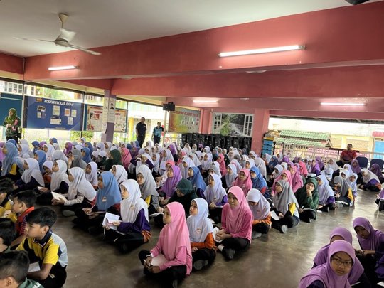 Ts. Lukas J. Tan giving a scam-awareness talk to students